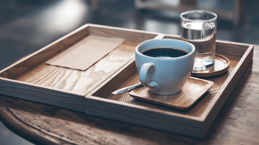A hot coffee sitting on a table.