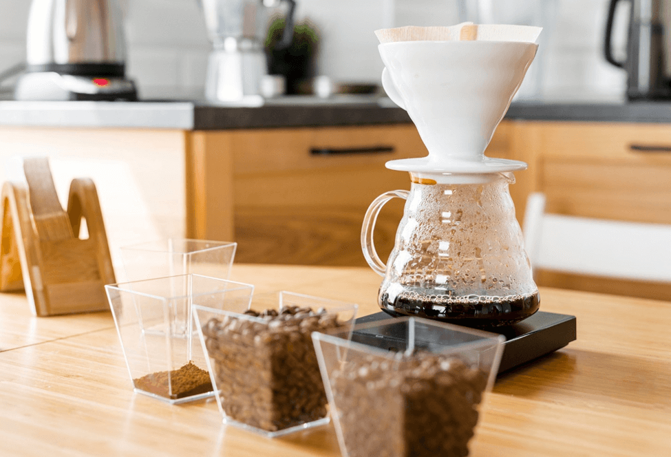 coffee filter and pour-over coffee on table with coffee beans infront